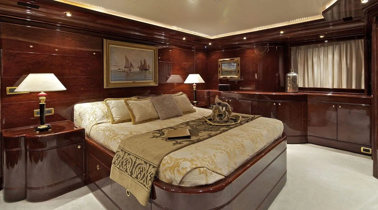 O'Rion yacht cabin interior with wood paneling, two twin beds, lamps, and framed artwork