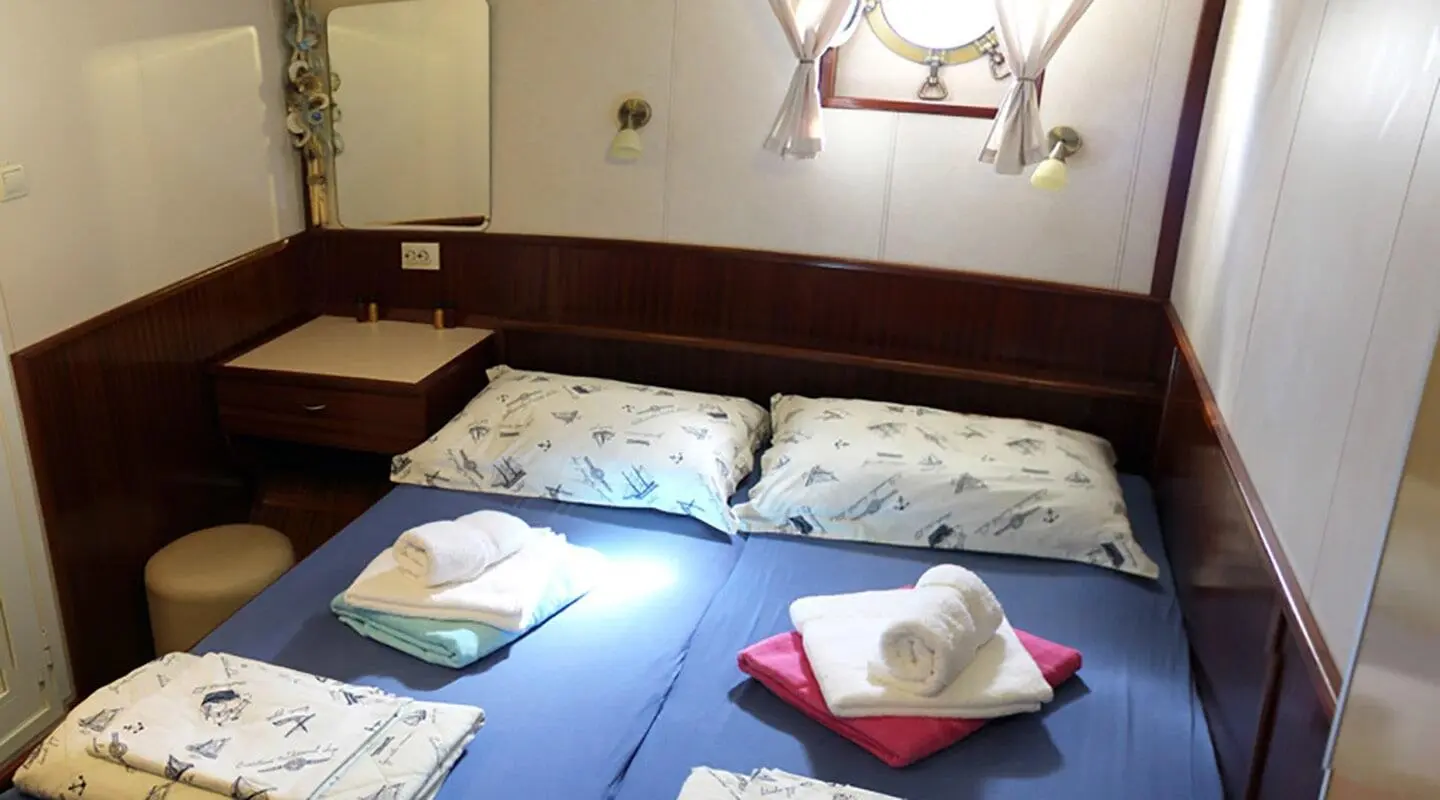 Tajna Mora luxury gulet interior with blue cushioned seating and towels