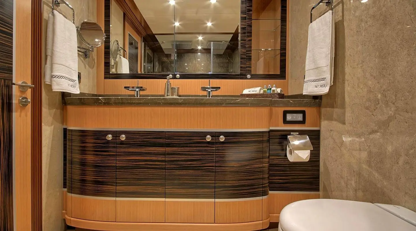 Meira yacht bathroom area with wooden cabinetry and double sink