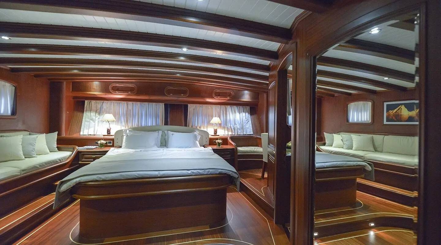Interior view of Lady Christa yacht: wood beams, beds, cabin lighting