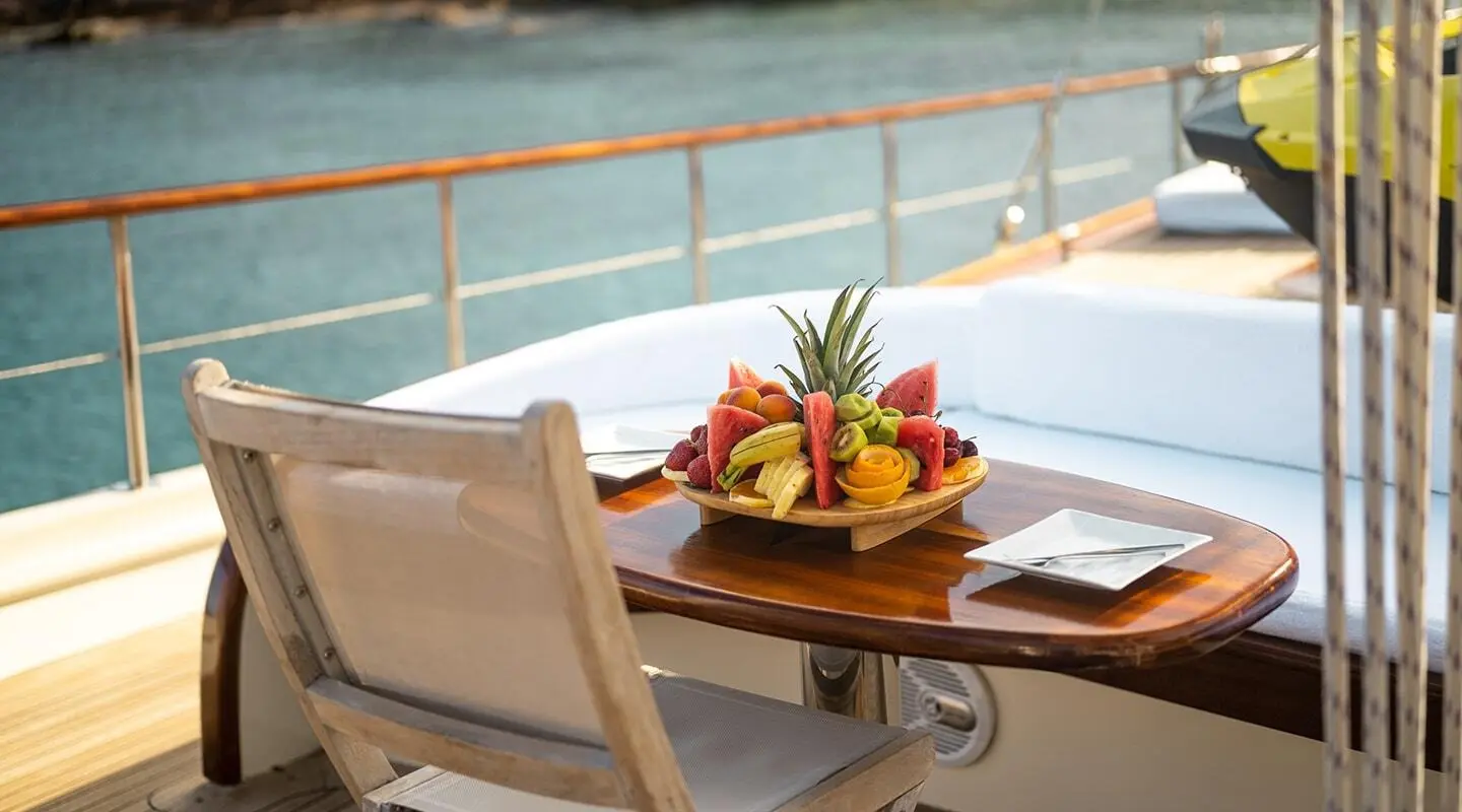 Estrella De Mar on a yacht deck with a fruit platter centerpiece on a wooden table