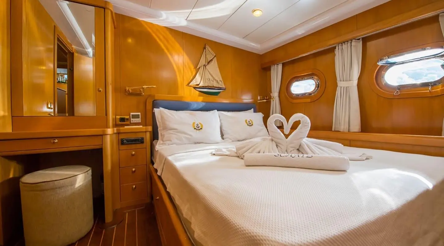 Double cabin on a gulet Mein Schatz yacht with wooden walls and bed