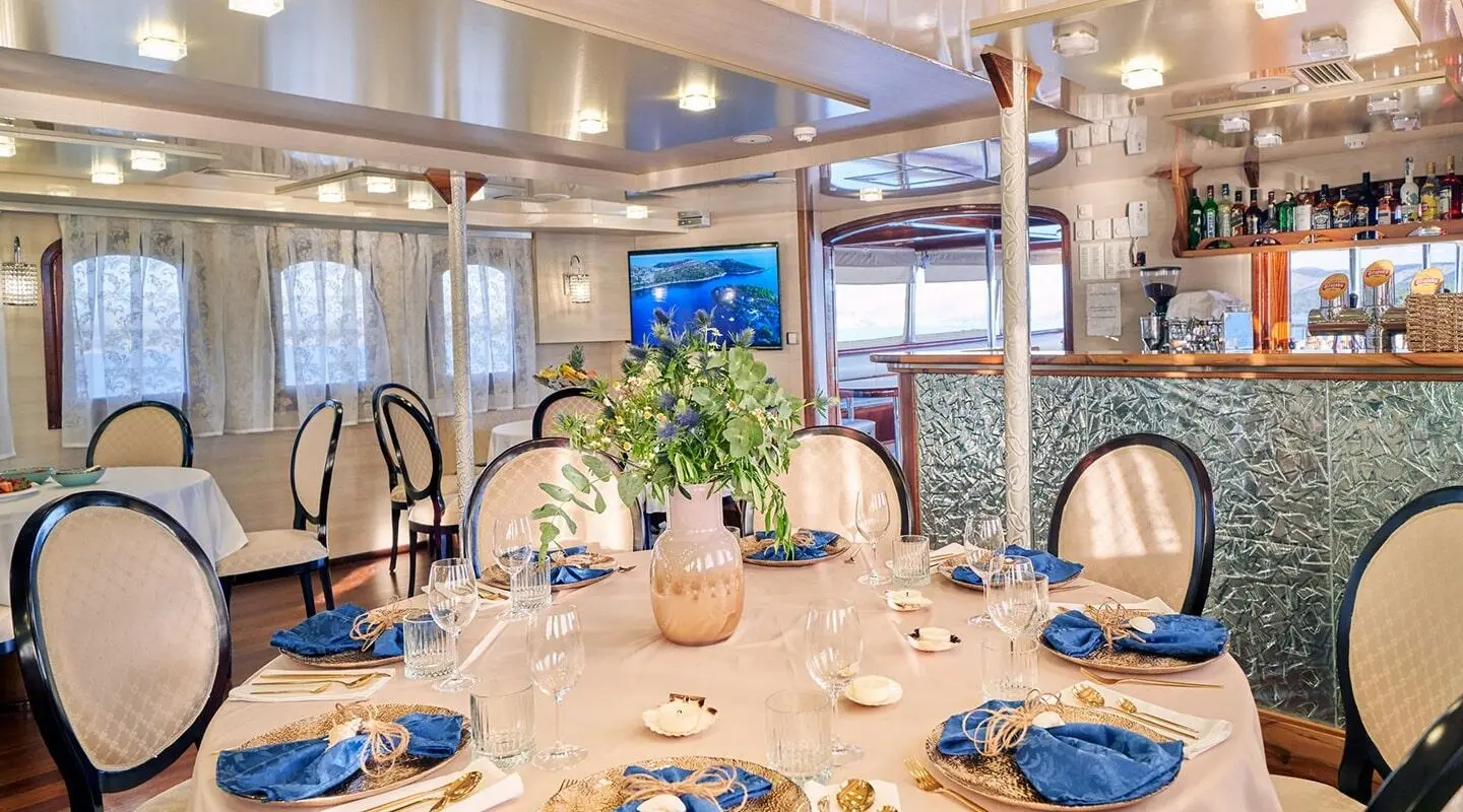 Casablanca yacht dining table set with plates, glasses, and floral centerpiece