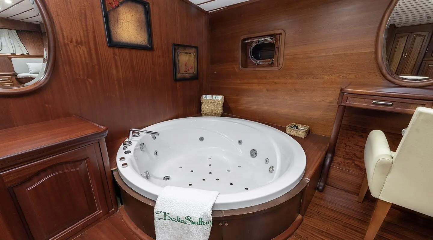 Yacht Bedia Sultan interior: wood paneling and round hot tub in cabin