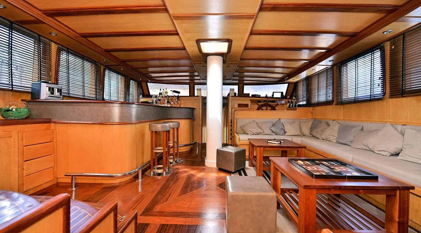 Interior of a wooden yacht saloon with polished benches and tables