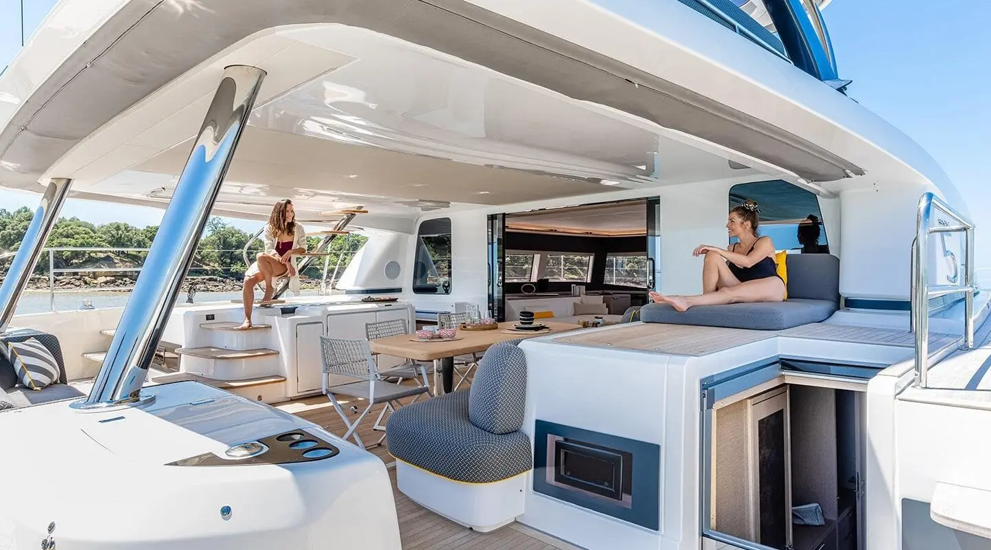 Daiquiri yacht deck: lounging seating, steering console, and sunlit helm area