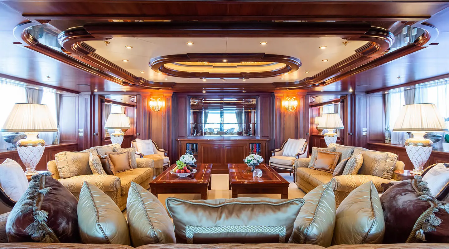 Elegant yacht saloon interior with plush seating and warm lighting at sunset