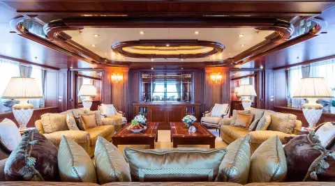 Elegant yacht saloon interior with plush seating and warm lighting at sunset