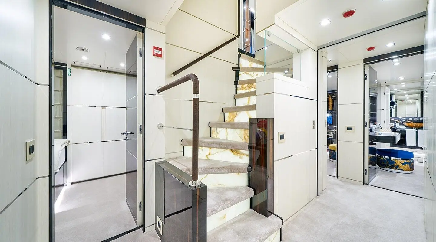 Interior staircase on a luxury motor yacht, white walls and glass panels