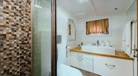Bathroom aboard yacht Maske, white cabinetry and helm area visible
