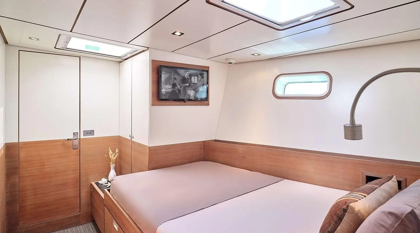 Aizu yacht interior with a built-in bed, wood cabinetry, and port window