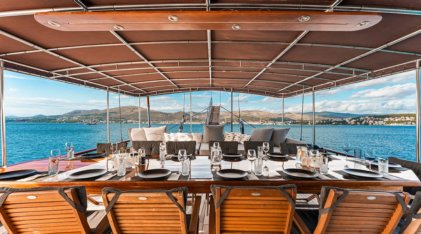 Croatia yacht dining area under canvas with wooden table and sea view