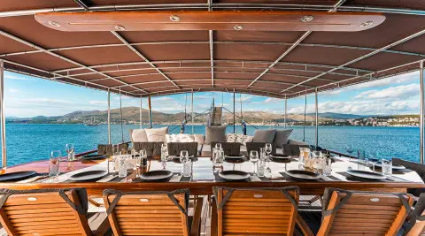 Croatia yacht dining area under canvas with wooden table and sea view