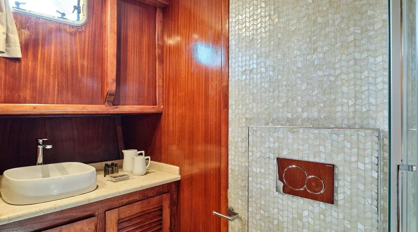 Wood-paneled interior with a bathroom sink on Myra yacht