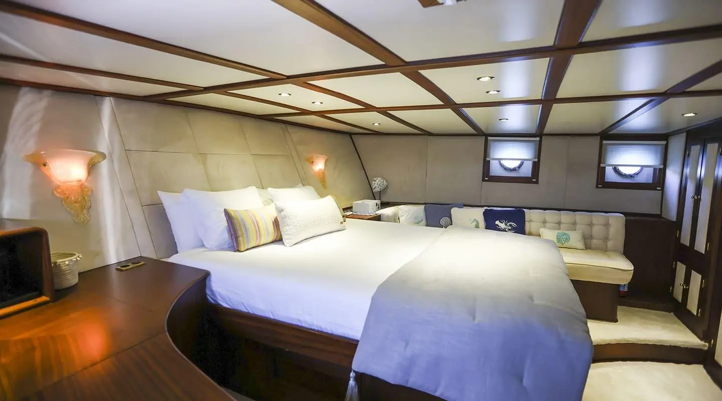 Gazella yacht interior with two neatly made beds and warm lighting