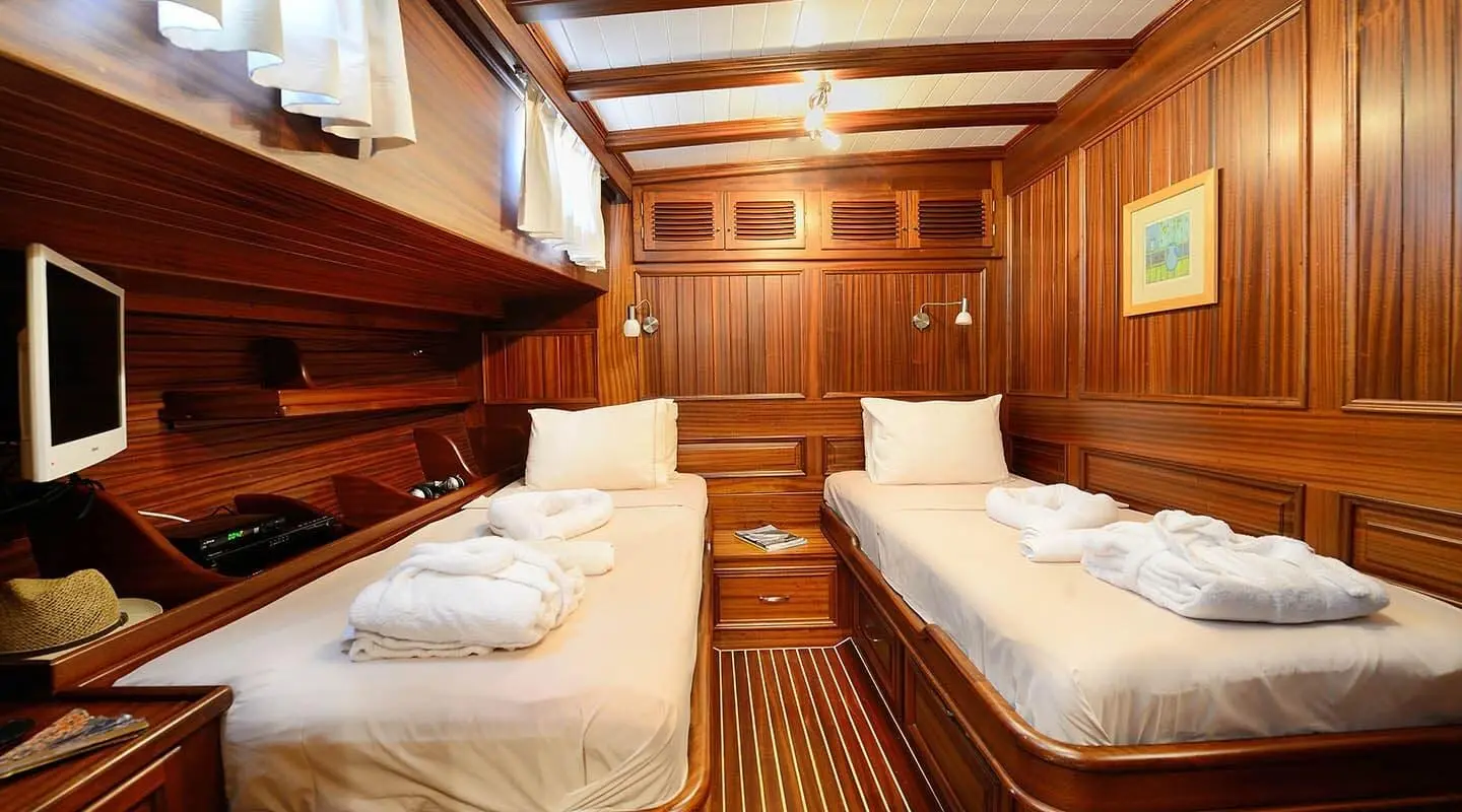 Interior of Zephyria II gulet with twin cabins, wooden paneling, and neatly made berths