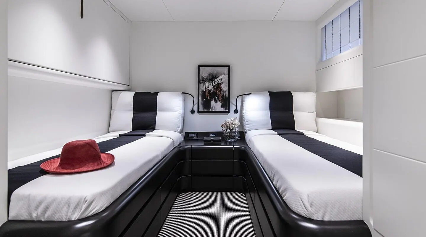 Inside view of a twin-cabin motoryacht with two single beds and cupboards