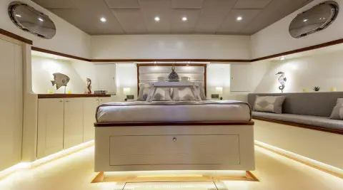 Luxurious yacht interior with curved sofa, dining area, and overhead lighting on Grand Sailor
