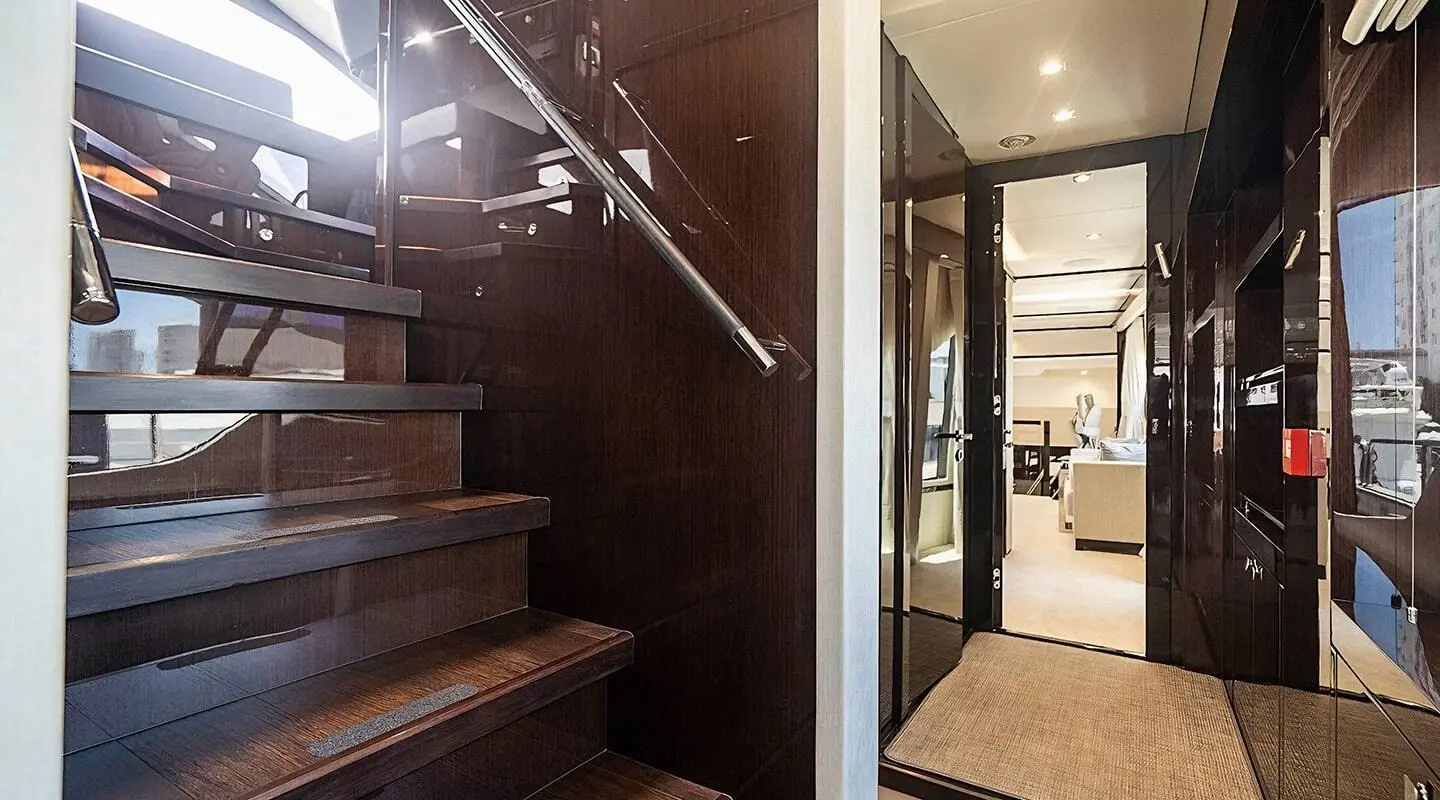 Quantum luxury yacht deck area with polished wood stairs and glass railing