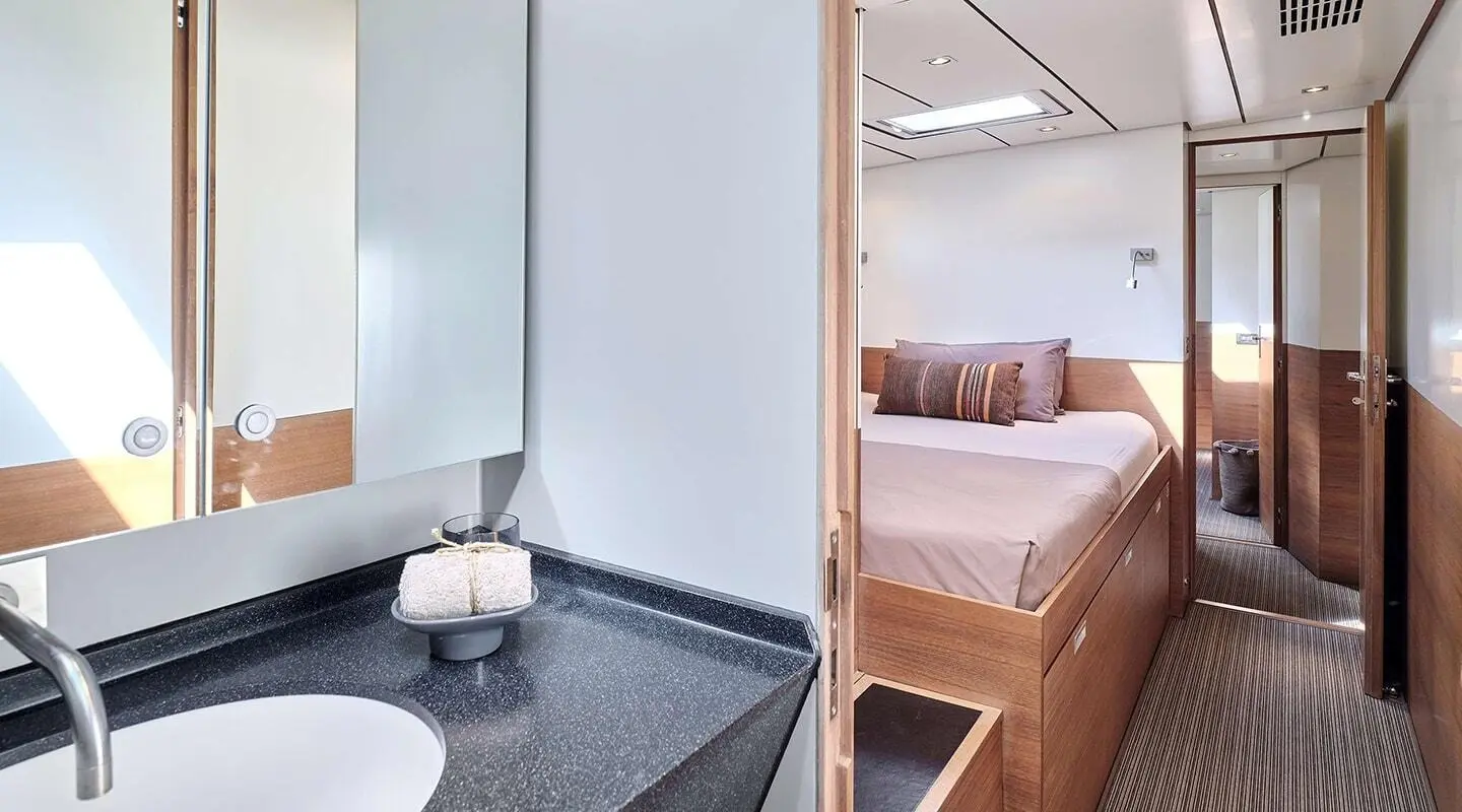 Aizu yacht interior showing bed with pillows and ensuite bathroom entry