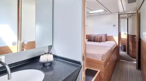 Aizu yacht interior showing bed with pillows and ensuite bathroom entry
