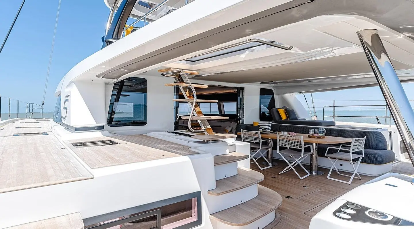 Aft deck of Daiquiri motor yacht with seating, table, and shaded helm area