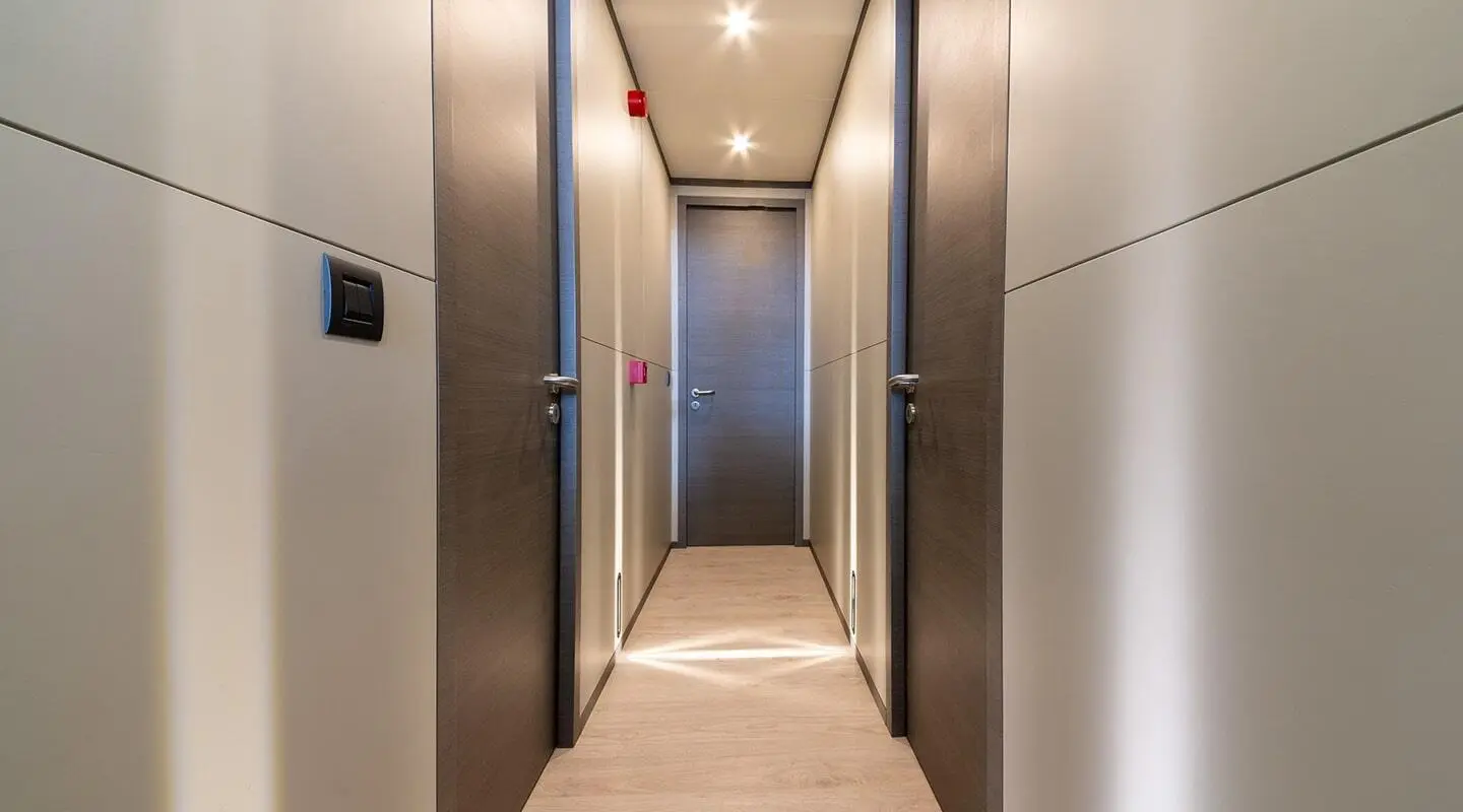 Narrow hallway on a yacht with side doors and a closed central door
