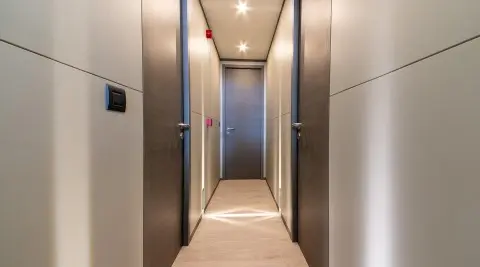 Narrow hallway on a yacht with side doors and a closed central door