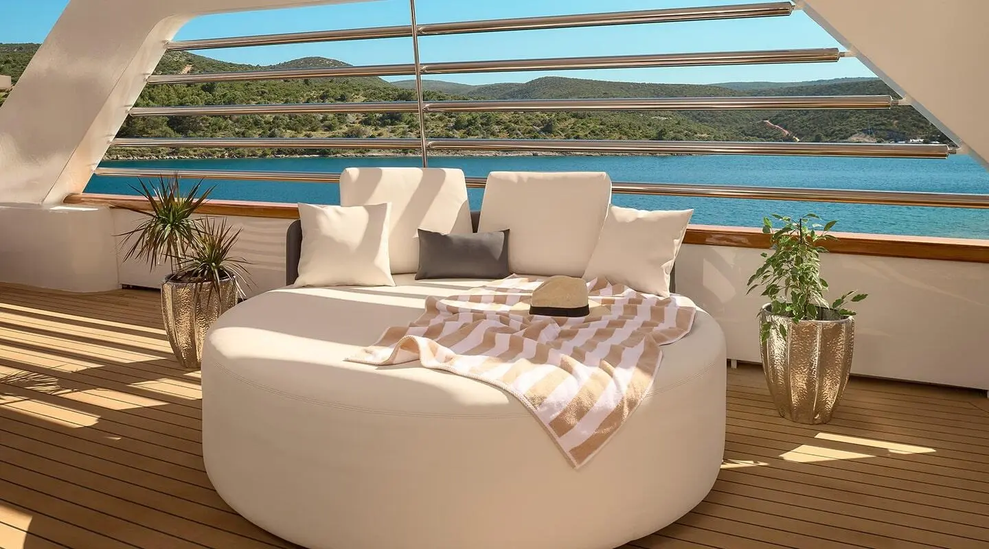 Cristal motor yacht upper deck with loungers and striped towel on deck