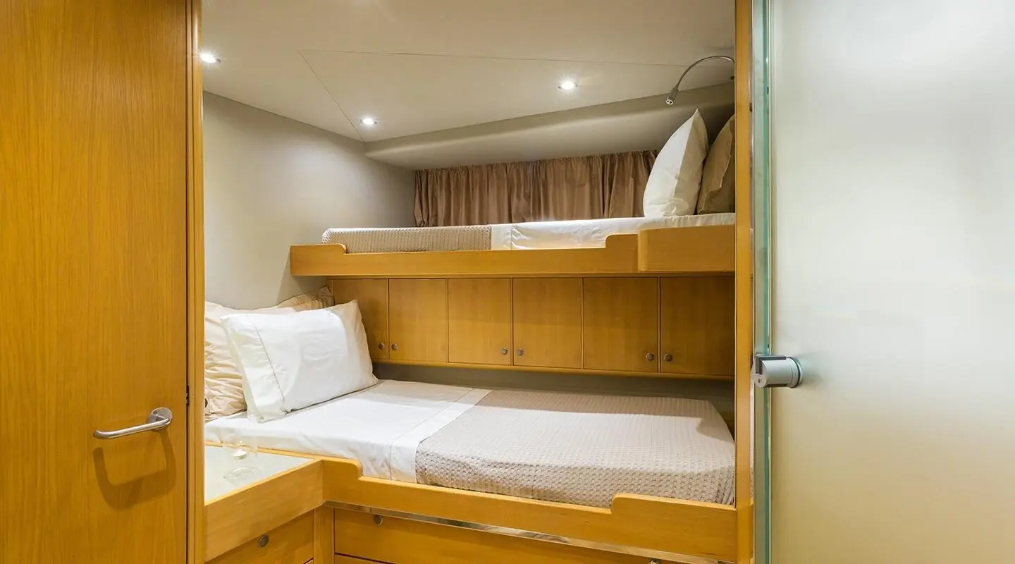 Inside bunk cabin on luxury yacht Aquarella with white bedding and wooden cabinetry