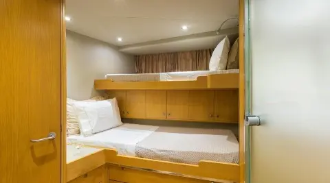 Inside bunk cabin on luxury yacht Aquarella with white bedding and wooden cabinetry