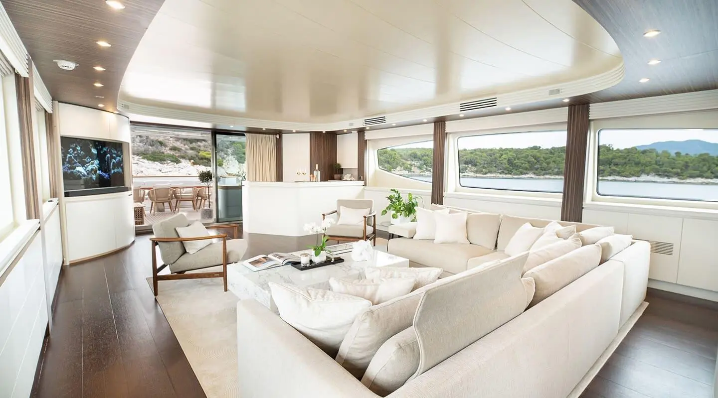 Pareaki II yacht interior saloon with white cushioned seating and panoramic windows