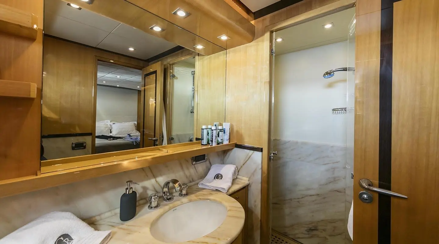 Bright yacht bathroom with sink, mirror, and wooden cabinetry on beige walls