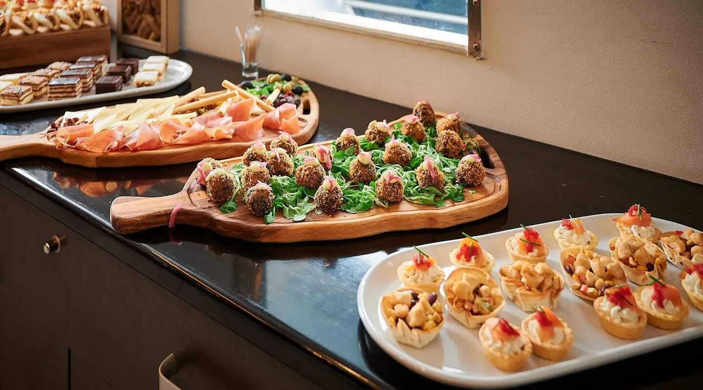 Lupus Mare yacht appetizers on a round tray with canapés and greens