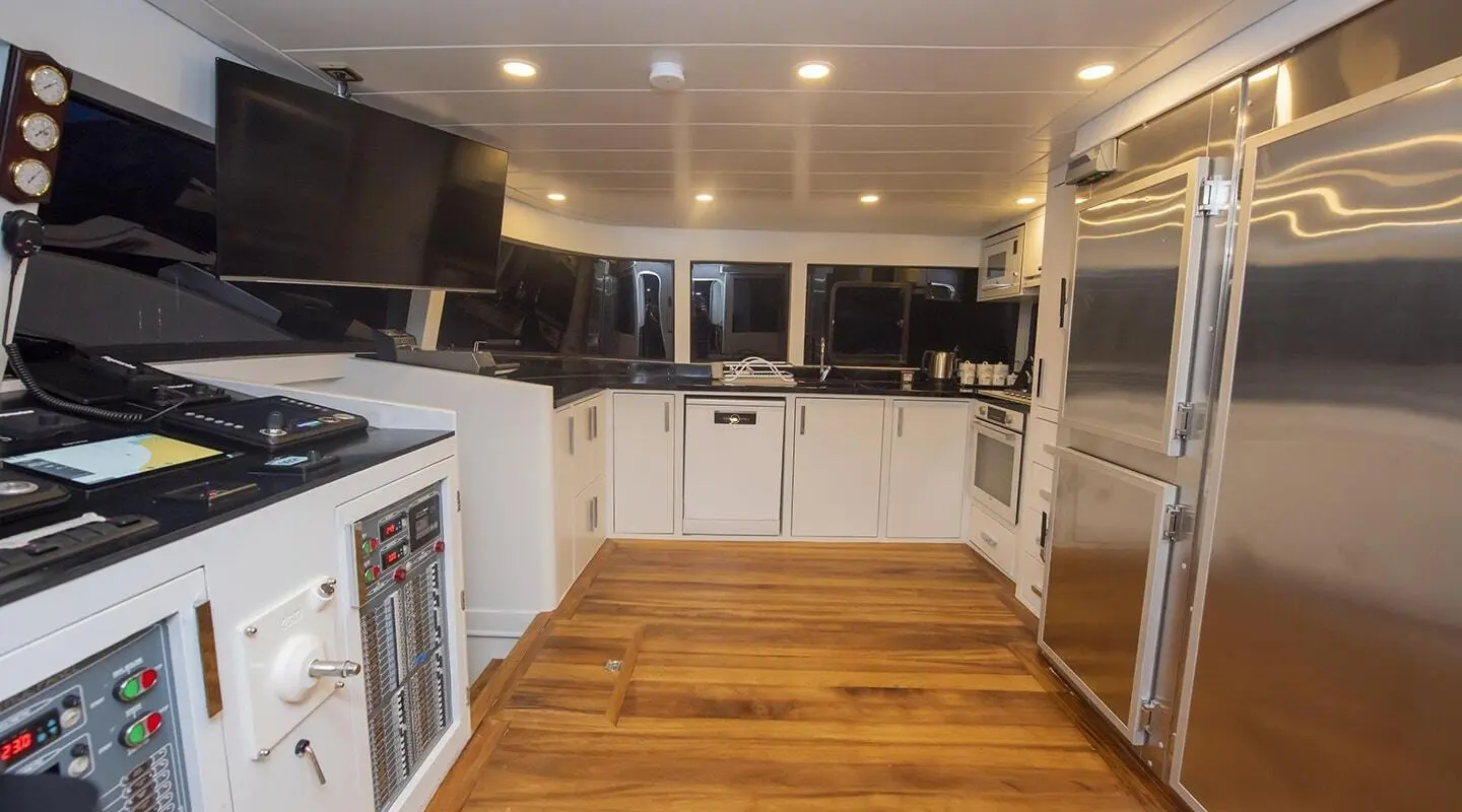 Interior of luxury yacht Simay M showing wooden floor, white cabinetry, and bright ceiling lights