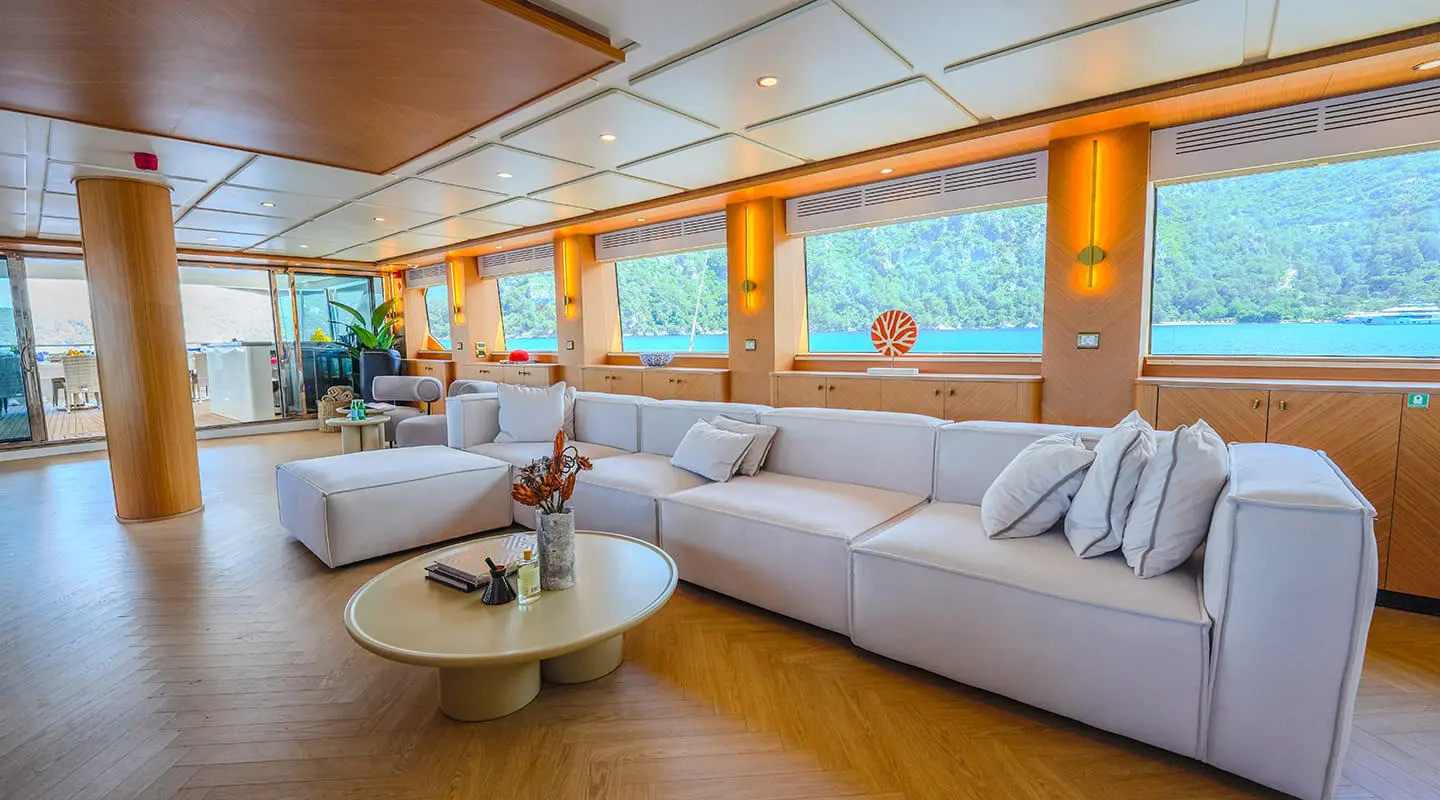 King of the Sea saloon interior with white sectional sofa and wooden accents
