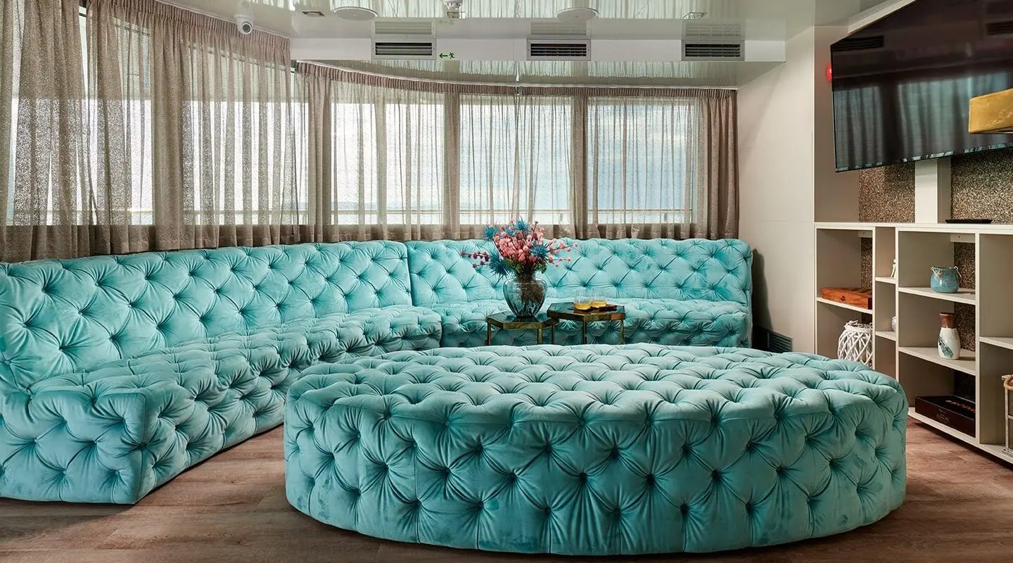 Ohana yacht deck saloon with turquoise tufted seating and large windows