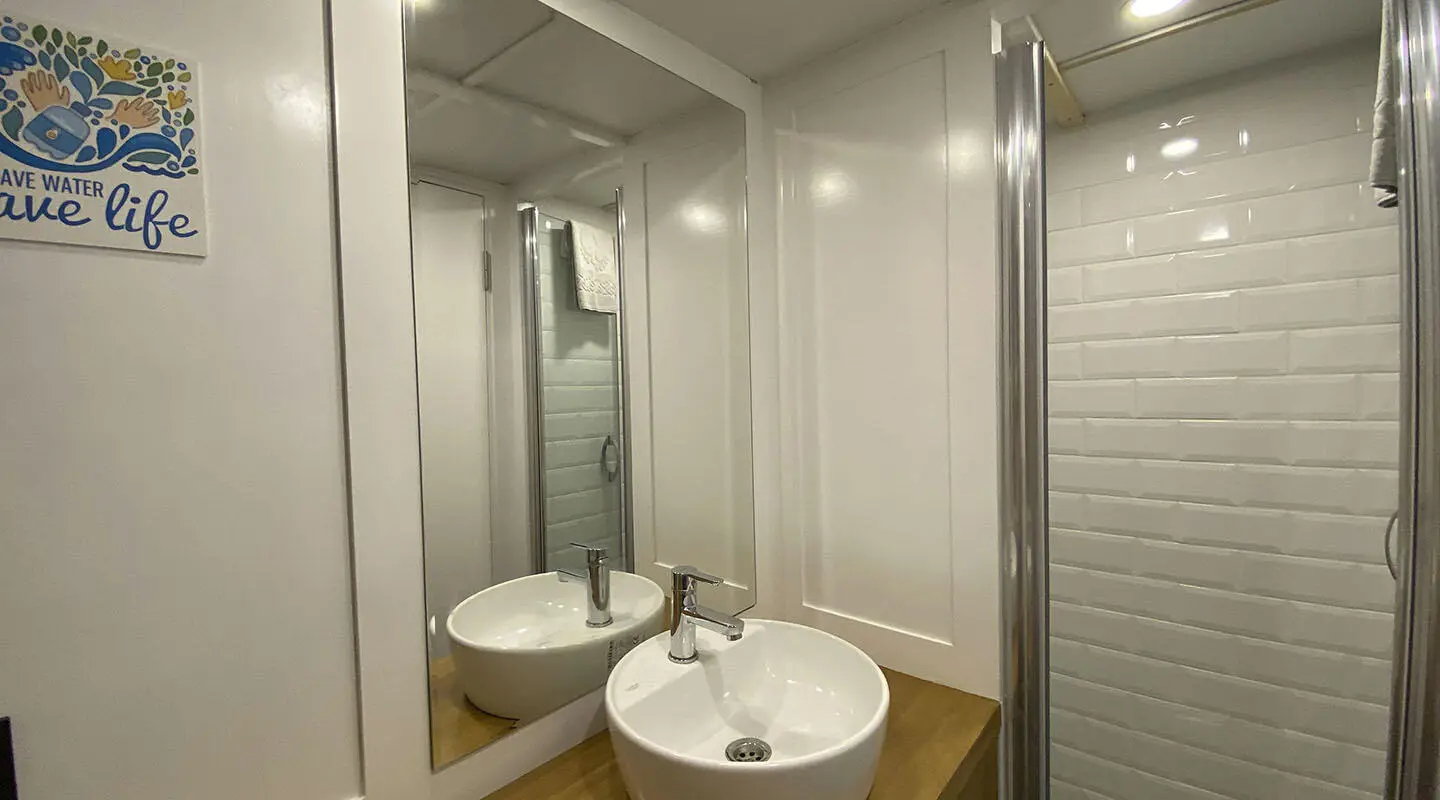 Maske 5 yacht bathroom with sink, mirror, shower enclosure and tiled walls