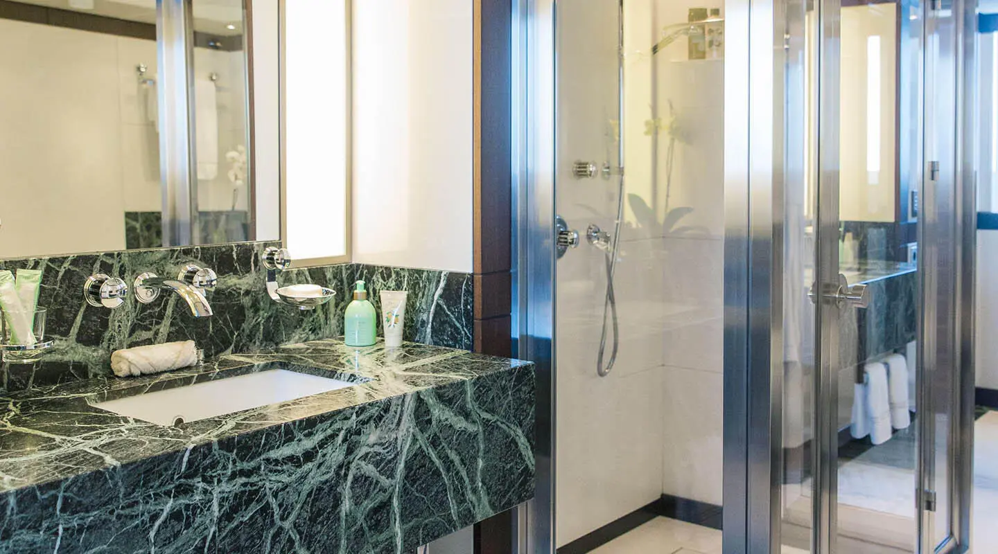 Alalya luxury yacht, elegant bathroom with green marble countertop and glass shower