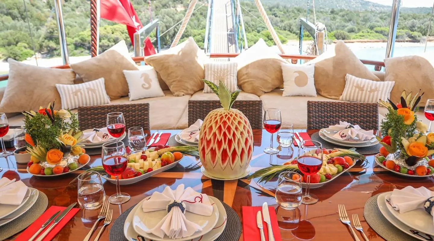 Glued gulet Ulucinar yacht dining table set with fruit and colorful decorations