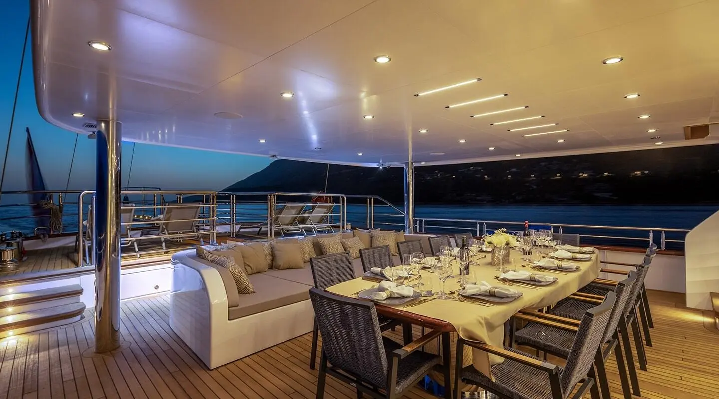 Yacht Love Story dining area on aft deck with arranged tables and chairs