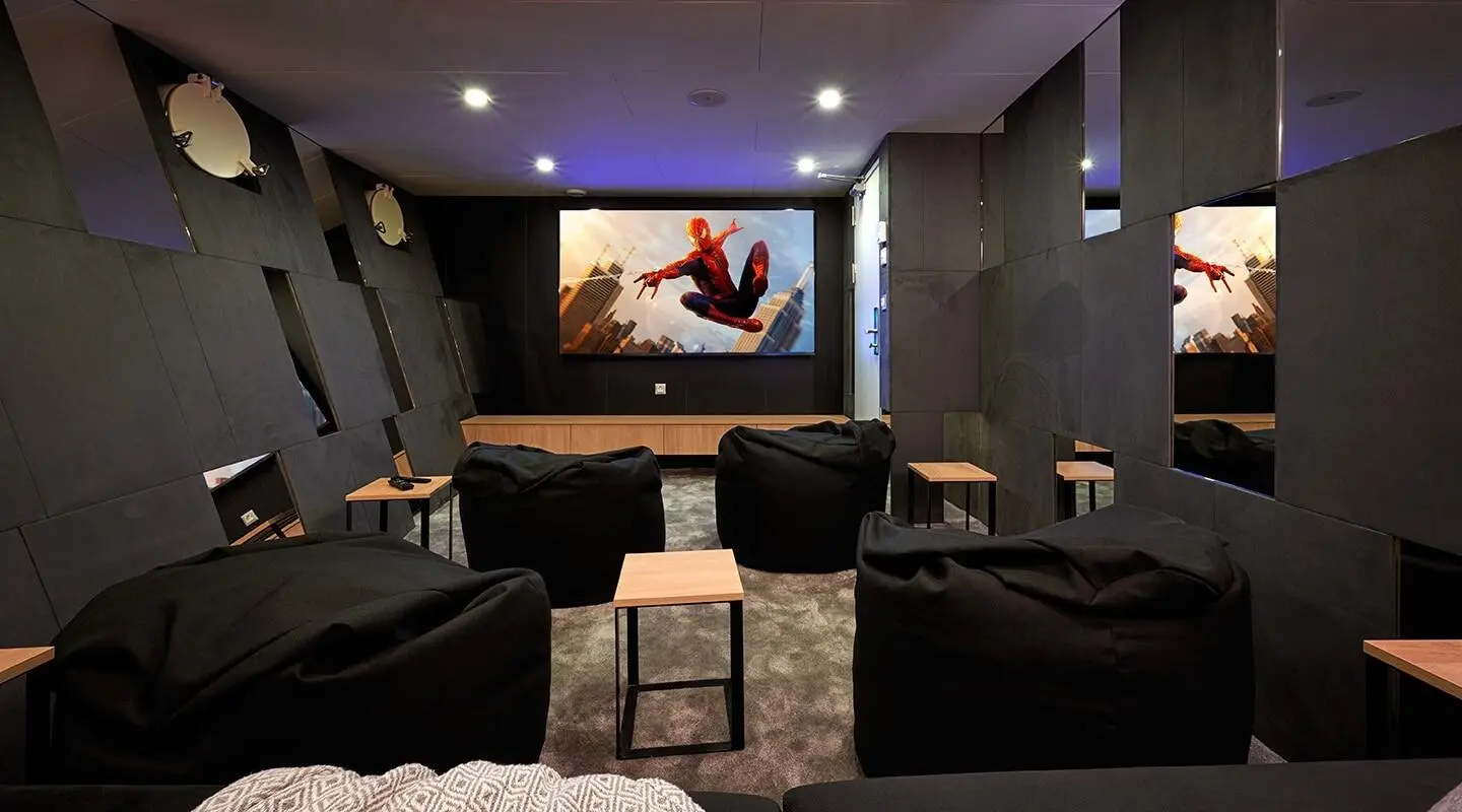 Ohana yacht cinema room with large screen, dark walls, and seating