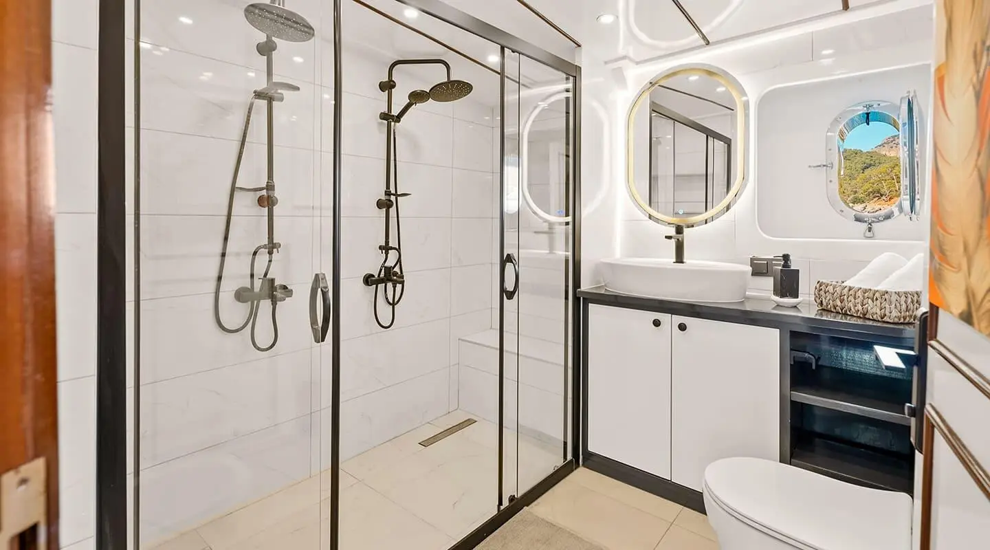 Bathroom on Esma Sultan gulet with glass shower enclosure and sink