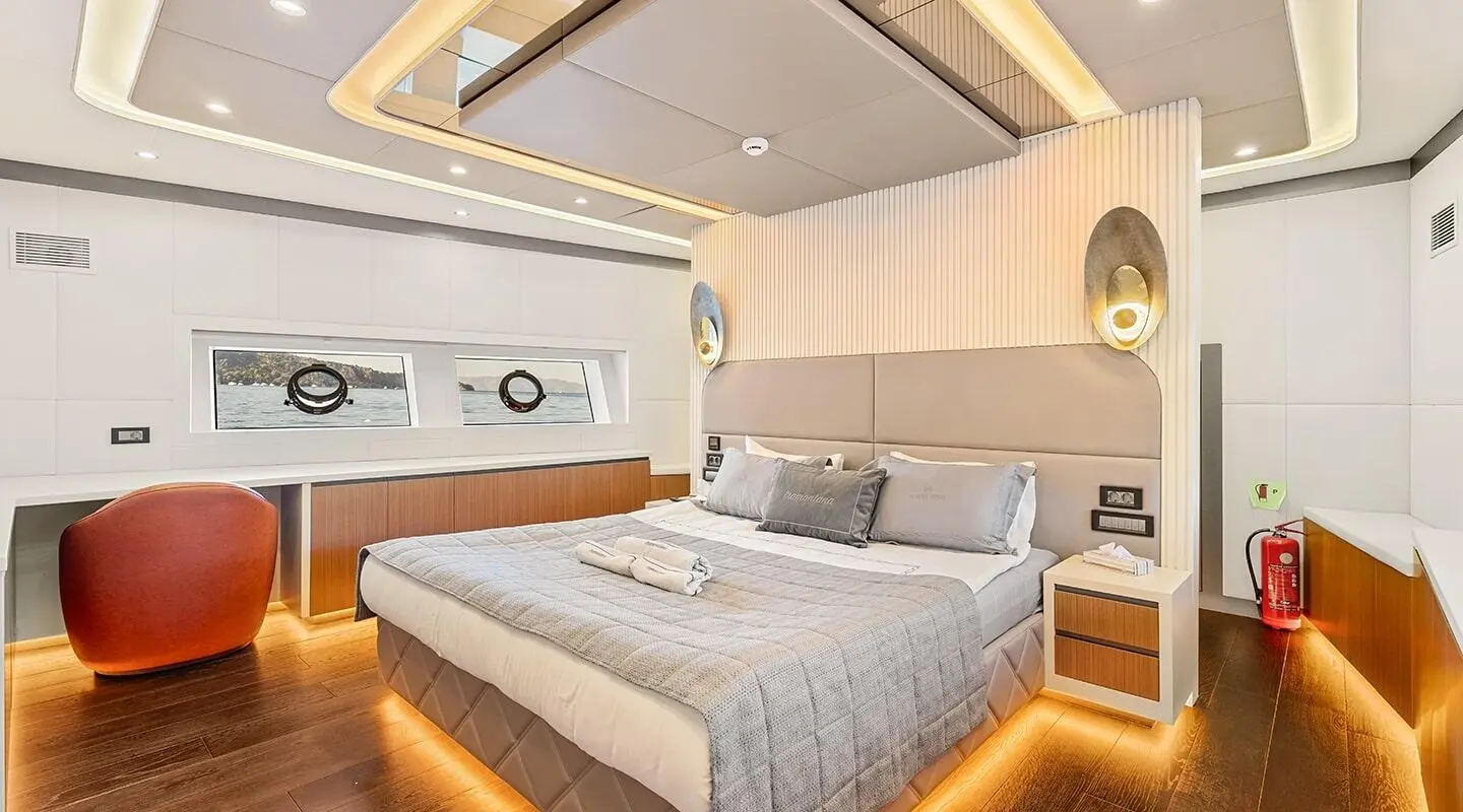 North Wind yacht interior: forward cabin with bed, wood floor, overhead cabinets