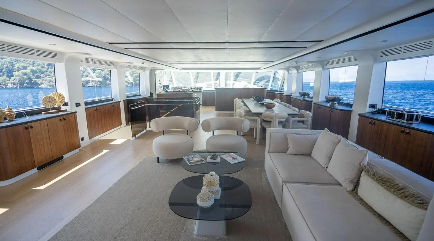 Interior of De Love yacht lounge with white sofas and circular coffee tables