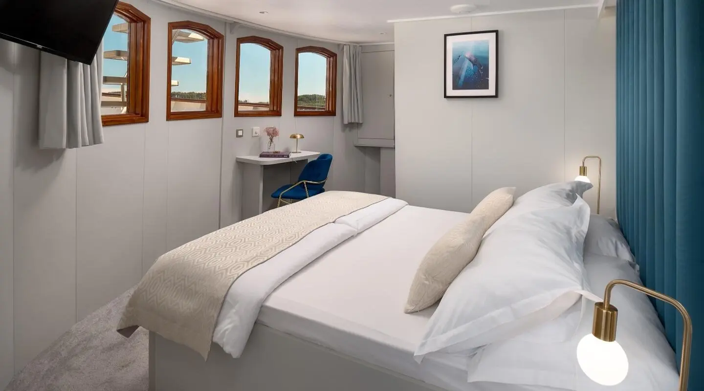 Bellezza yacht stateroom with two beds, beige linens, and framed windows