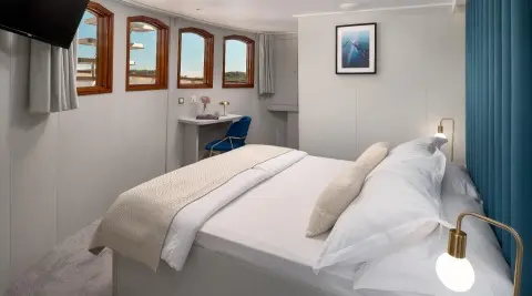 Bellezza yacht stateroom with two beds, beige linens, and framed windows