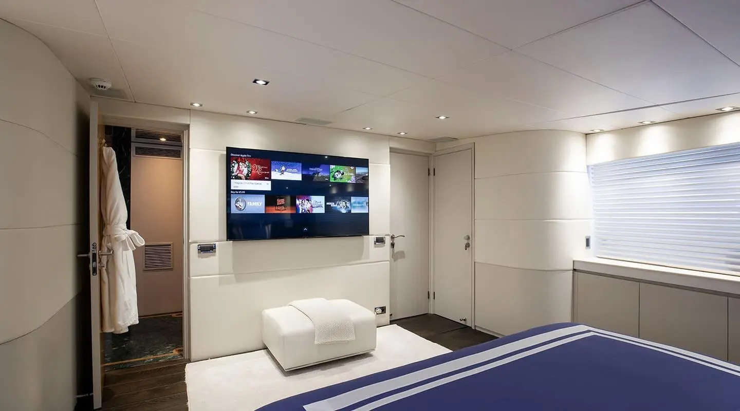 Yacht Brooklyn master cabin interior with bed, TV wall, and seating area