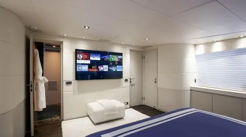Yacht Brooklyn master cabin interior with bed, TV wall, and seating area