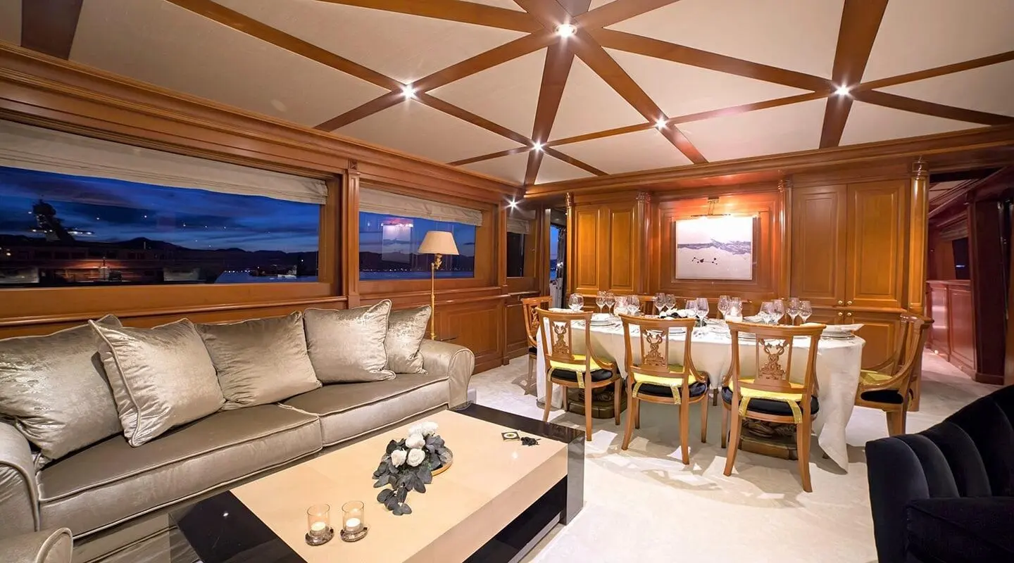 Aquila luxury yacht interior with cream seating, wood panels, and dining area